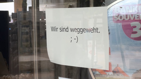 In einem geschlossenen Geschäft steht auf einem Schild: Wir sind weggeweht ;) © NDR 