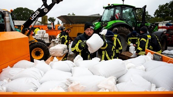 Grömitz: Feuerwehrleute füllen Sandsäcke wegen eines Sturmtiefs. © dpa Foto: Daniel Bockwoldt