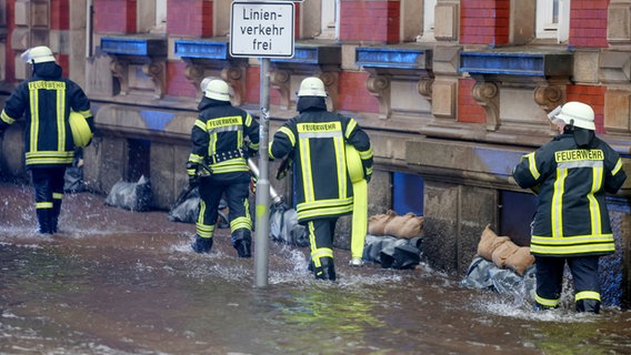 Einsatzkräfte der Feuerwehr sind bei einer Sturmflut in der Flensburger Innenstadt unterwegs. © dpa-Bildfunk Foto: Frank Molter