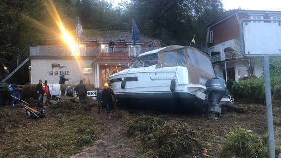 Nach der Sturmflut: In Wassersleben in Harrislee liegt ein Boot vor einem Vereinsheim. © NDR Foto: Birte Steuer