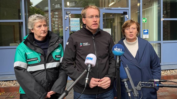 Katja Günther, Daniel Günther und Sabine Sütterlin-Waack stehen vor mehreren Mikrophonen © NDR Foto: Constantin Gill