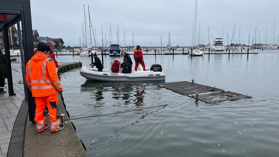 Personen in einem Boot holen ein Teil eines Steges ein. © NDR Foto: Hauke von Hallern