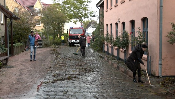 Einwohner bei Aufräumarbeiten nach einem Sturmtief in Schleswig. © TNN 
