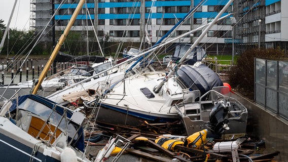 Beschädigte Schiffe liegen im Hafen von Damp nach der Sturmflut auf einem Anleger. © dpa Foto: Daniel Bockwoldt