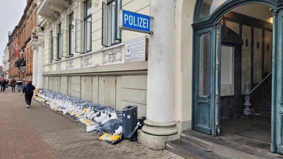 Vor einer Polizeidienststelle in Flensburg sind Sandsäcke gelagert. © NDR Foto: Frank Goldenstein