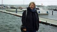 Susanne Schöning steht in einem Hafen und lächelt in die Kamera. © Susanne Schöning Foto: Susanne Schöning