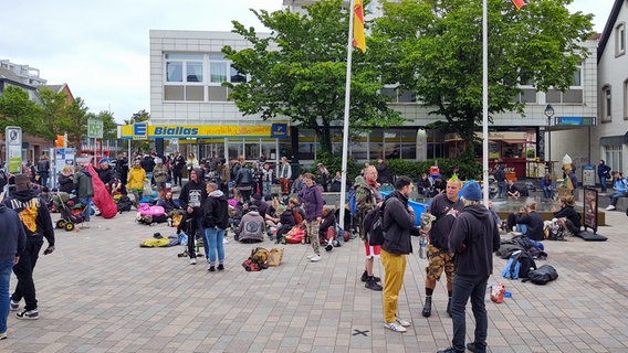 Punks und schwarzgekleidete junge Menschen haben sich vor einem Platz in der Westerländer Fußgängerzone niedergelassen. © NDR Foto: Peer-Axel Kroeske