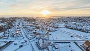 Eine Drohenenaufnahme zeigt eine Ortschaft auf Sylt von oben bei Sonnenaufgang. © Studio Sylt Foto: Georg Heimberger