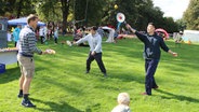 Menschen spielen auf einer Wiese mit Tennisschlägern. © NDR Foto: Torsten Creutzburg