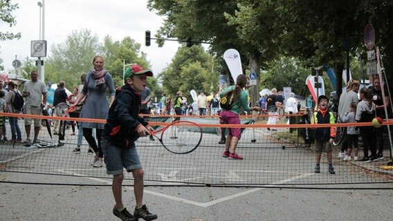 Menschen spielen Tennis auf einer abgesperrten Straße am Tag des Sports.  Foto: Torsten Creutzburg