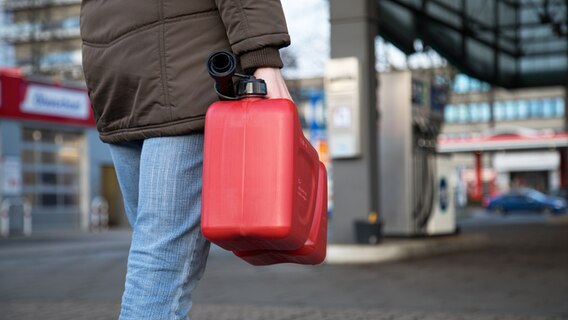 Eine Person geht am mit einem Kanister zu einer Tankstelle © picture alliance Foto: Christin Klose