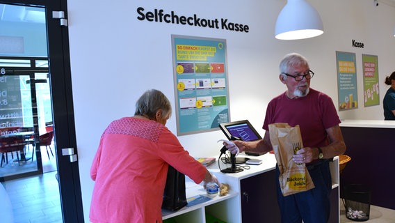 Kunden packen ihre Lebensmittel-Einkäufe ein. © NDR Foto: Denise Klein