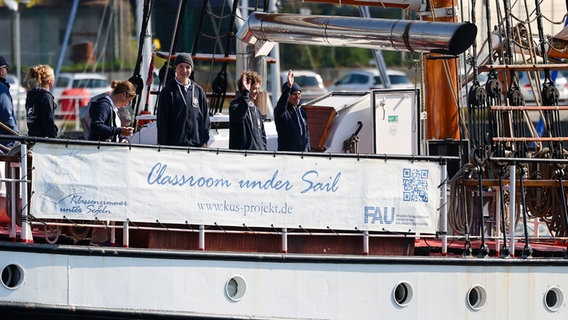 Schülerinnen und Schüler stehen an Bord des Ausbildungsschiffs «Thor Heyerdahl» beim Einlaufen in Kiel. © dpa-Bildfunk Foto: Frank Molter