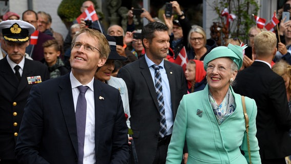Ministerpräsident Daniel Günther (CDU) steht neben Margrethe II. von Dänemark vor einer Menschenmenge. © picture alliance/dpa Foto: Carsten Rehder