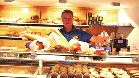 Ein Bäcker zeigt einige seiner Produkte. © NDR Foto: Andrea Schmidt