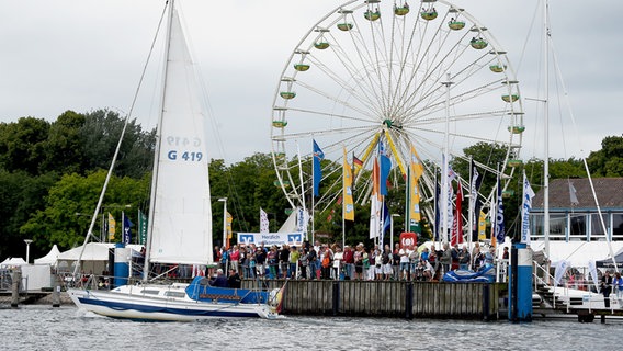 Besucher der Travemünder Woche stehen am Ufer der Trave. © dpa | picture alliance Foto: Carsten Rehder