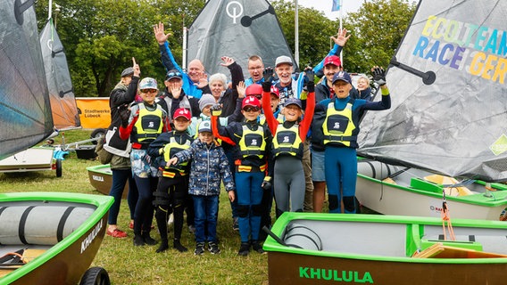 Eine Gruppe mit Kindern und Erwachsenen posieren vor ihren Segelbooten für ein Foto Eine Gruppe mit Kindern und Erwachsenen posieren vor ihren Segelbooten für ein Foto © TW Presse Foto: Christian Beeck