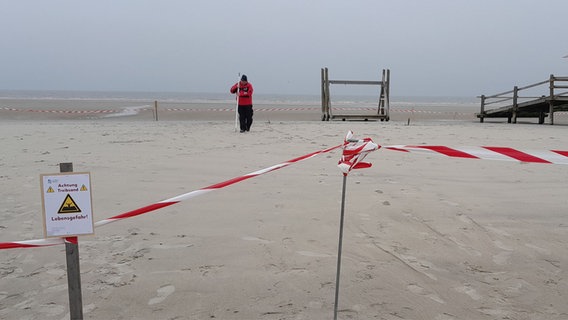 Ein Schild warnt vor Treibsand an einem Strand. © NDR Foto: Anne Passow