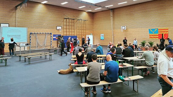 Zahlreiche Menschen sitzen auf Bänken in einer Sporthalle © Ole Steffen Foto: Ole Steffen