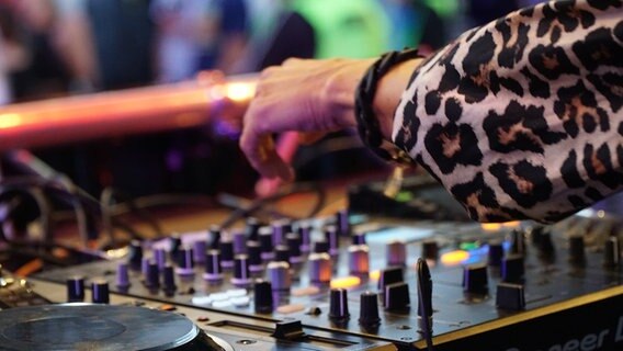 Eine Hand von DJ 2Elements über den Reglern des DJ Pults. © NDR Foto: Christian Wolf