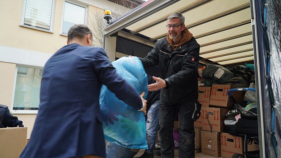 Freiwillige helfen beim Entladen und Sortieren der Hilfsgüter für die Ukraine im polnischen Wlodawa. © NDR Foto: Hauke Bülow