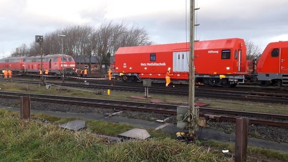 Am Bahnhof von Westerland auf Sylt steht ein roter Notfalltechnik-Zug der Bahn auf einem Gleis mit einer entgleisten Lok © Ralf Limberger Foto: Ralf Limberger