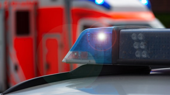 Ein Einsatzfahrzeug, Streifenwagen der Polizei mit Blaulicht, im Hintergrund sieht man einen Rettungswagen. © Fotostand / Gelhot 
