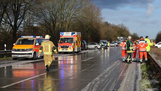 Mehrere Feuerwehrleute stehen an einer Unfallstelle auf der A23 nach einem Hagelschauer. © Westküsten-News / Florian Sprenger Foto: Westküsten-News / Florian Sprenger