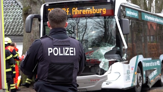 Polizist steht vor beschädigtem Bus nach Unfall in Großhansdorf © NonstopNews 