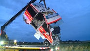 Ein beschädigter Rettungswagen wir von einem Kran abtransportiert. © NDR 