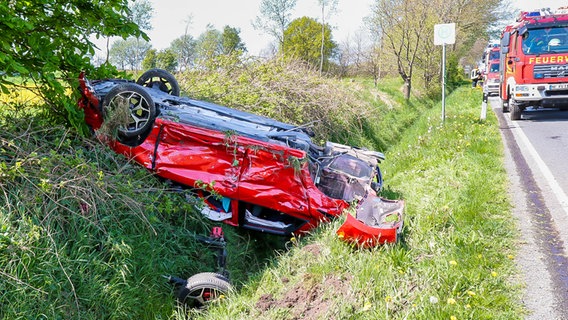 Ein verunfalltes Auto liegt im Straßengraben, am Straßenrand steht die Feuerwehr. © Sebastian Iwersen Foto: Sebastian Iwersen