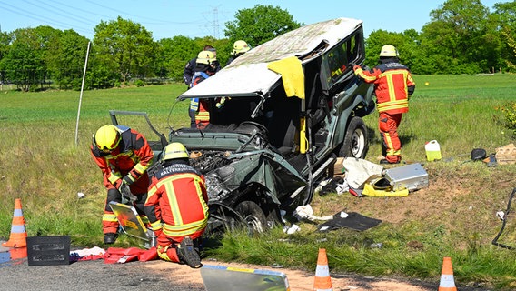 Feuerwehrleute arbeiten am zerstörten Unfallfahrzeug im Graben neben der Fahrbahn. © picture alliance/dpa | Jonas Walzberg Foto: Jonas Walzberg