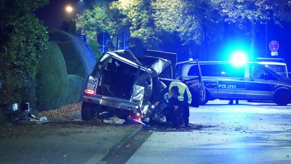 Eine Mercedes G-Klasse zerstört auf dem Gehweg. Im Hintergrund ein Polizeiwagen mit Blaulicht. © Danfoto Foto: Danfoto
