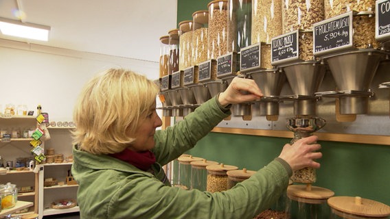 Ein Frau füllt sich Müsli ab, in einem "unverpackt"-Laden. © NDR 