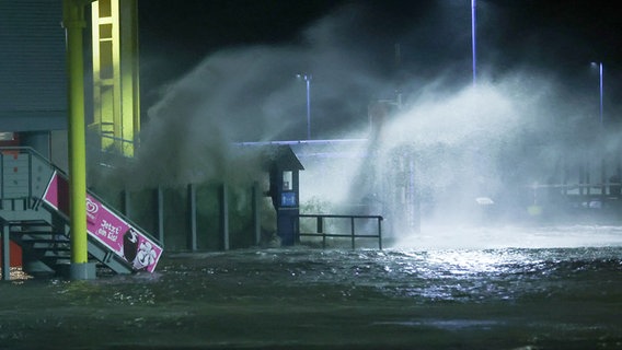 Die Gischt der aufgepeitschten Nordsee überflutet bei Sturm den Fähranleger Dagebüll. © dpa-Bildfunk Foto: Bodo Marks