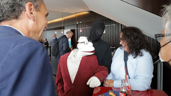 Menschen stehen neben der Figur von Werner Momsen im Ohnsorg Theater in Hamburg beim "Vertell doch mal". © NDR Foto: Oke Jens