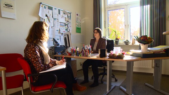 Zwei Frauen führen in einem Büro ein Gespräch. © NDR 
