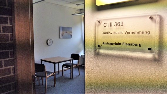Auf dem Türschild steht "Audiovisuelle Vernehmung - Amtsgericht Flensburg" © Peer-Axel Kroeske 