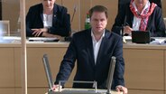 Christopher Vogt, Fraktionsvorsitzender von FDP,  steht am Rednerpult im Landtag. © NDR 