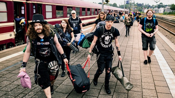 Besucher des Wacken Open Air verlassen am Bahnhof Itzehoe den von München aus gestarteteten Metal Train, um das nach Veranstalterangaben größte Heavy-Metal Festival der Welt zu besuchen. © dpa-Bildfunk Foto: Axel Heimken
