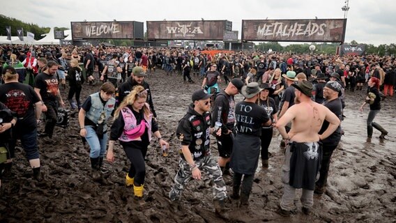 Metal-Fans warten an einem der Eingänge auf die Öffnung des Festivalgeländes. © dpa Foto: Christian Charisius