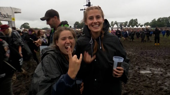 Zwei Frauen stehen beim Wacken Open Air und machen den Metalgruß © NDR Foto: NDR Screenshots