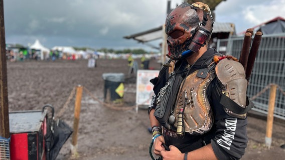 Eine Person steht bei dem Wacken Open Air in einer Verkleidung die an die "Mad Max"-Filme erinnert. Er ist Teil der "Wasteland Warriors". © NDR Foto: Tobias Gellert