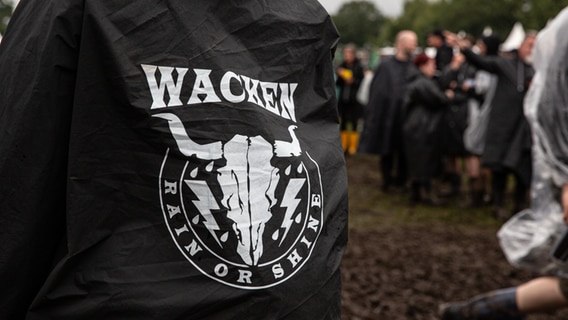 Auf einem Poncho Ist das Logo des Wacken Open Air abgebildet. Eingefasst wird es von den Worten: Rain or Shine. © NDR Foto: Christoph Klipp
