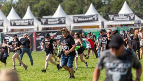 Menschen rennen jubelnd auf ein Festivalgelände. © NDR Foto: Dominik Dührsen