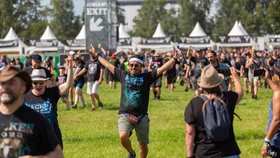 Menschen rennen jubelnd auf ein Festivalgelände. © NDR Foto: Dominik Dührsen