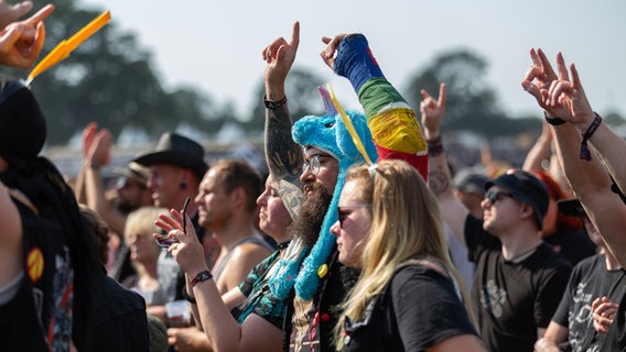 Menschen jubeln einer Band auf einem Open-Air-Konzert zu. © NDR Foto: Dominik Dührsen