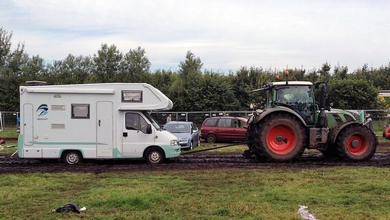 Wohnmobil wird von Traktor durch Schlamm gezogen. © NDR Foto: Constantin Gill