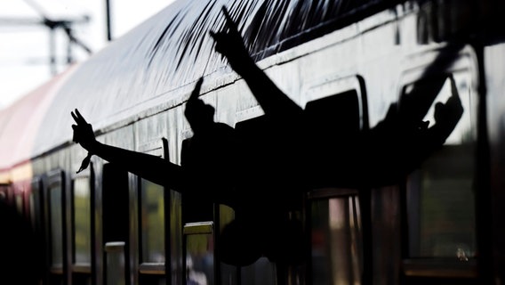 Mehrere Hände mit dem Metal-Gruß ragen aus dem Fenster des Sonderzuges © dpa-Bildfunk Foto: Frank Molter