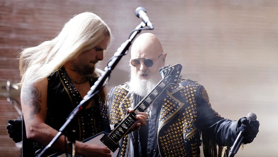 Gitarrist Richie Faulkner (l) und Sänger Robert Halford stehen zusammen während eines Auftritts der britischen Band «Judas Priest» beim WOA - Wacken Open Air © picture alliance/dpa | Frank Molter Foto: Frank Molter